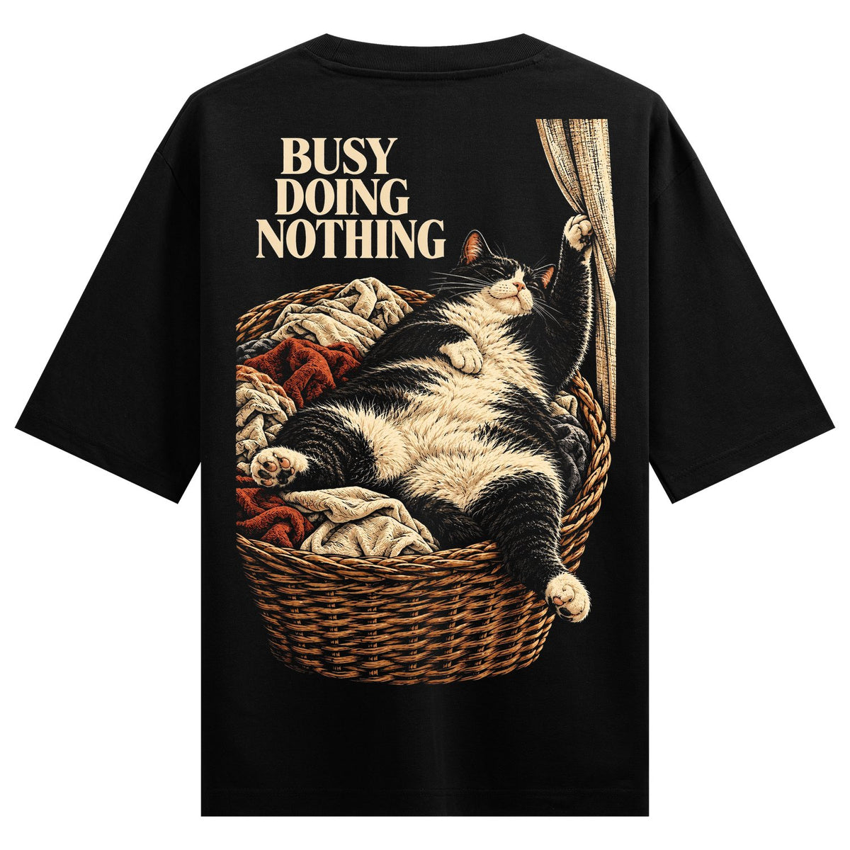 Lazy Cat Basket Oversized T-Shirt — a black and white cat lounging in a brown woven basket filled with red