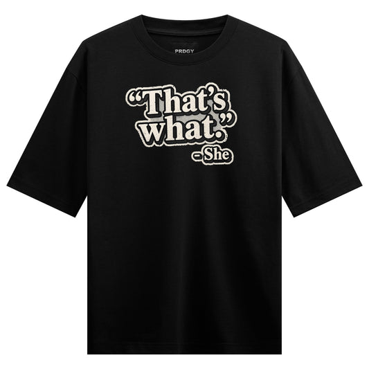 Black t-shirt with white and grey outlined text reading That s what followed by She in a smaller font on PRDGY oversized t...