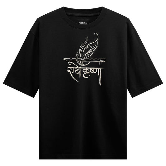 A black t-shirt features white Indian calligraphy for Radha Krishna accompanied by a flute and a stylized feather design o...