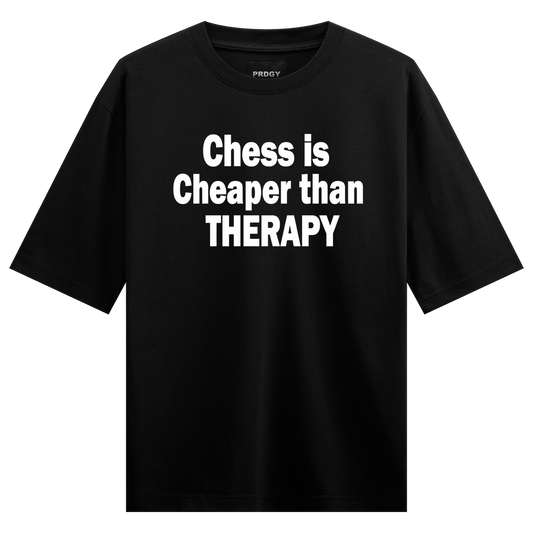 White sans-serif text on a black t-shirt reads Chess is Cheaper than THERAPY with a small PRDGY logo above on PRDGY oversi...