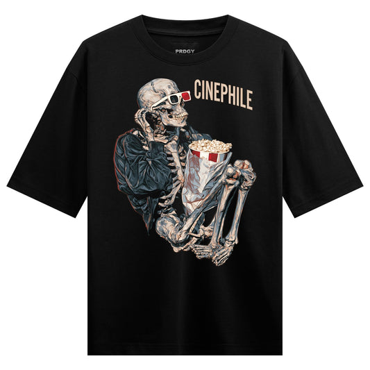 Skeleton Movie Night Oversized T-Shirt — a skeleton wearing red 3D glasses holds a popcorn bucket while seated