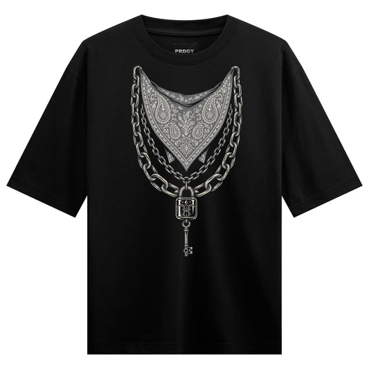 A black t-shirt displays a central graphic of a grey bandana pattern surrounded by silver chains a padlock and a key on PR...
