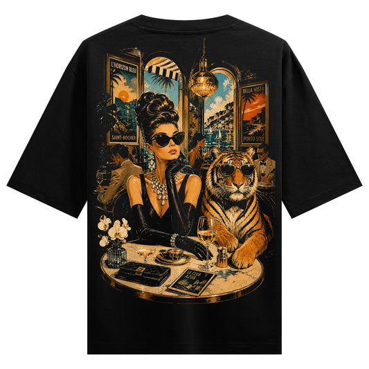 A stylish woman in sunglasses with pearls sits beside a tiger at a round table with drinks and decor on PRDGY oversized t...