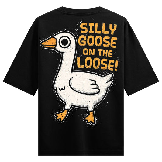 A black t-shirt features a white cartoon goose illustration with an orange beak and yellow text reading SILLY GOOSE ON THE...