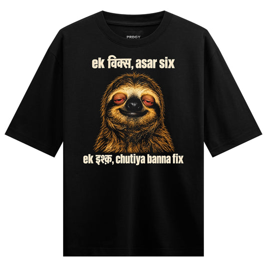 A brown sloth with half-closed eyes smiling overlaid with cream-colored Hindi text on a black tee on PRDGY oversized t-shirt