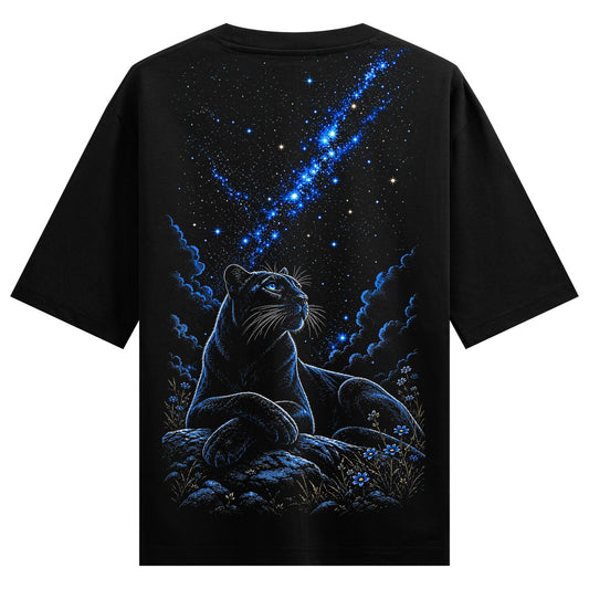 A black panther with bright blue eyes lies on rocks under a dark sky filled with a blue nebula and white stars with small...