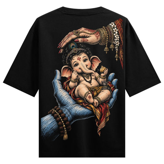 A baby Ganesha sits in a large blue hand with a woman s henna-adorned hand above all on a black t-shirt on PRDGY oversized...