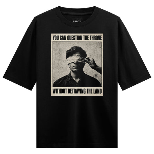 A monochrome portrait of a man with a blindfold being adjusted by a hand with bold text above and below on PRDGY oversized...