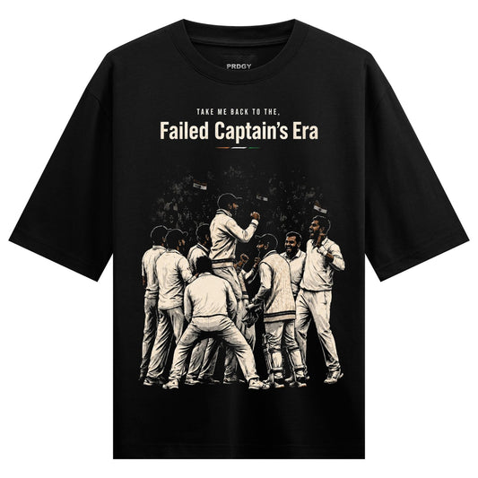 A black t-shirt features an illustration of a group of cricket players in a huddle with confetti falling around them with...