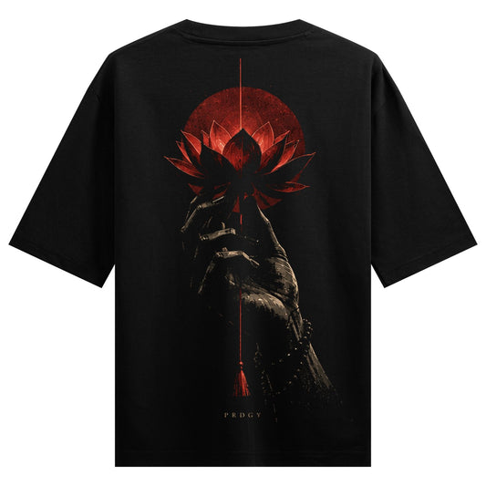 Lotus Offering Oversized T-Shirt — a dark hand holds a red lotus flower against a red sun with a hanging tassel