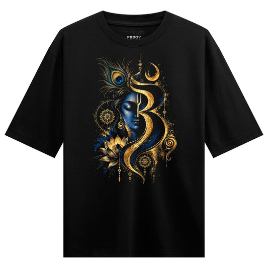 A black t-shirt features a central design of a serene blue face with a gold Om symbol peacock feathers and lotus flowers a...