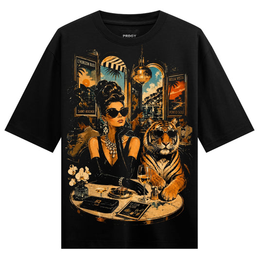 A woman and tiger wearing sunglasses sit at a café table with wine glasses a book and vintage posters on a black tee on PR...