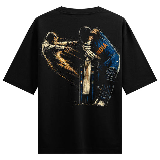 A black t-shirt back print features a dynamic illustration of a cricket player in a blue jersey mid-swing with a bat surro...