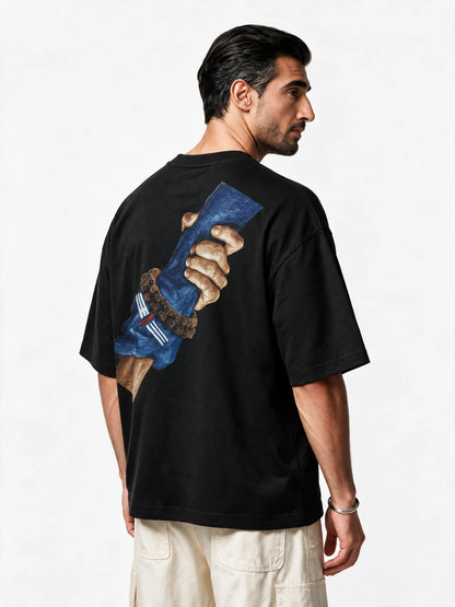 PRDGY Sahayak Oversized T-Shirt — back-print T-shirt at three-quarter angle